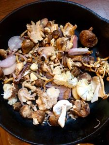 mushrooms, scallions and garlic in the cast iron pan ready to roast